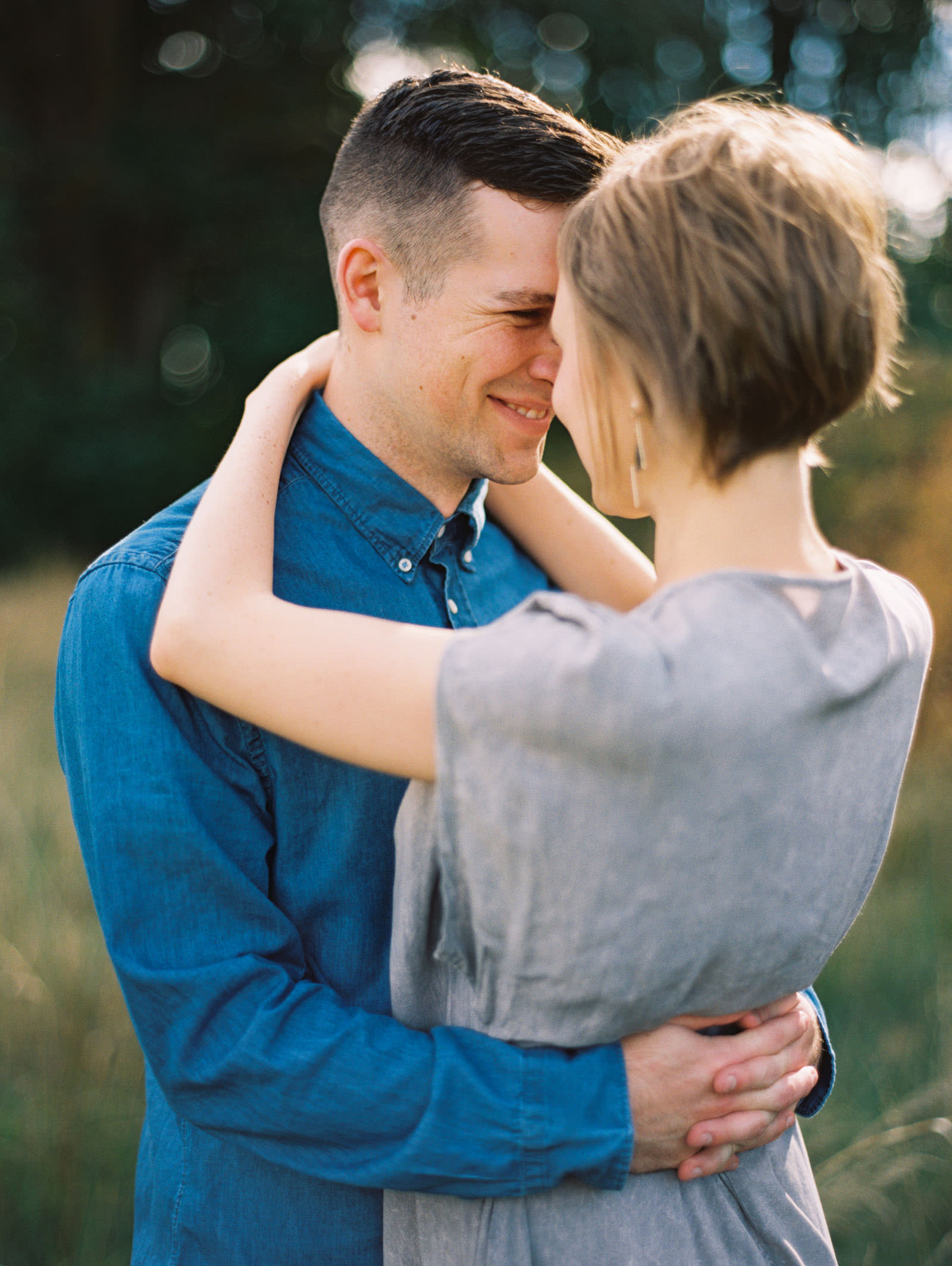 Snuggling close at a discovery park engagement session captured by Seattle FIlm Wedding Photographer Anna Peters